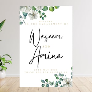 May include: White and green floral engagement announcement sign with the text "Welcome to the engagement of Waseem and Amina 27th May 2023 Thank you for joining us".