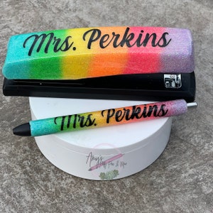 May include: A rainbow glitter stapler and pen set with the name "Mrs. Perkins" on both items.