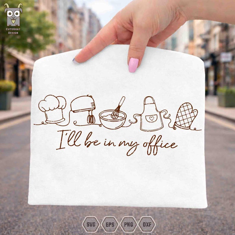 May include: White kitchen towel with a brown line drawing of chef's hat, mixer, bowl with whisk, apron, and oven mitt. The text "I'll be in my office" is below the drawings. The towel is held up by a hand.