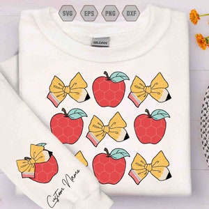 May include: White sweatshirt featuring a repeating pattern of red apples and yellow bows with pencil accents. The left sleeve has a single apple and bow design with the text "Custom Name". The design is suitable for back-to-school or teacher-themed apparel.