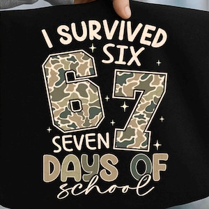 May include: Black tote bag with the text "I Survived Six 67 Seven Days of School." The numbers 6 and 7 are filled with a camouflage pattern. The text is in a mix of fonts and colors.