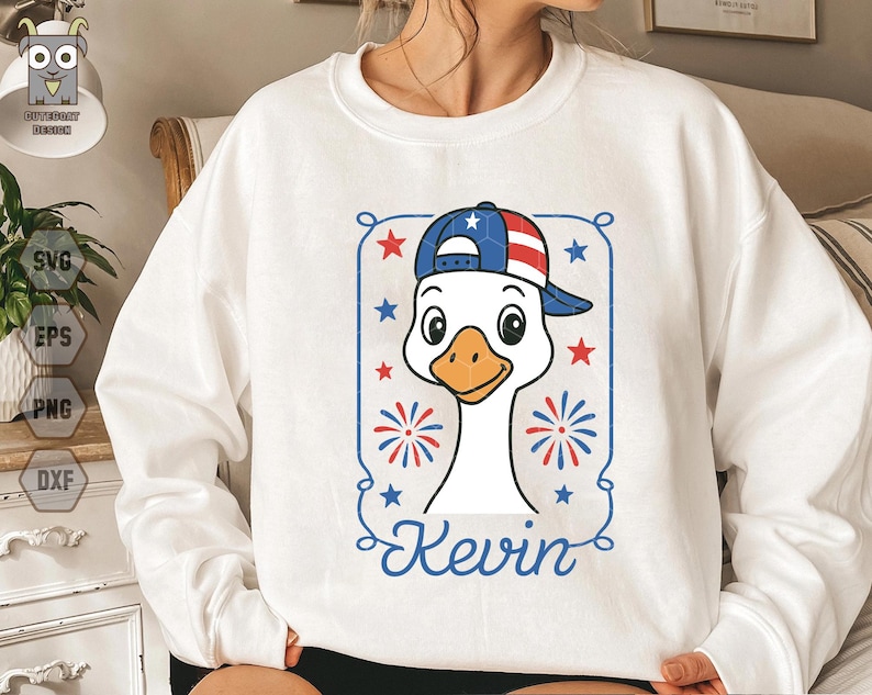 May include: White sweatshirt with a cartoon goose wearing a red, white, and blue baseball cap. The goose is wearing a red, white, and blue baseball cap with stars. The text "Kevin" is printed below the goose.