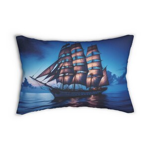 May include: A blue and white pillow with a picture of a large sailing ship with white sails against a blue sky and ocean.