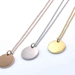 Peut inclure: Trois colliers avec des pendentifs ronds, vierges, en métal. Les pendentifs sont en or, argent et or rose.