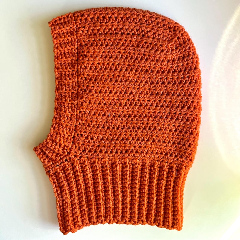 Crochet balaclava hood pattern in burnt orange. Easy beginner-friendly crochet pattern with ribbed neck.