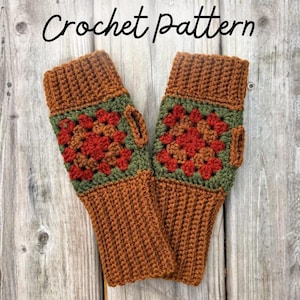 Könnte beinhalten: Ein Paar fingerlose Handschuhe mit einem Häkelmuster, das ein zentrales quadratisches Motiv in Rot-, Orange- und Olivgrüntönen aufweist. Die Handschuhe haben gerippte Bündchen aus einfarbigem braunem Garn und eine Daumenöffnung.