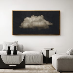 May include: A black and white photograph of a single cloud against a dark background. The cloud is large and fluffy, and the image is framed in a thin, gold frame.
