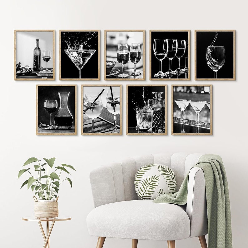 May include: Set of eight black and white photographs featuring various cocktails and drinks. The photos are framed in a simple wooden frame and are arranged in a grid pattern on a white wall.