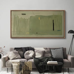 May include: Abstract art print in a wooden frame. The artwork features a muted green and olive color palette with vertical and horizontal brushstrokes. A black vertical line and a small yellow square add contrast to the design. The artwork is displayed above a sofa.