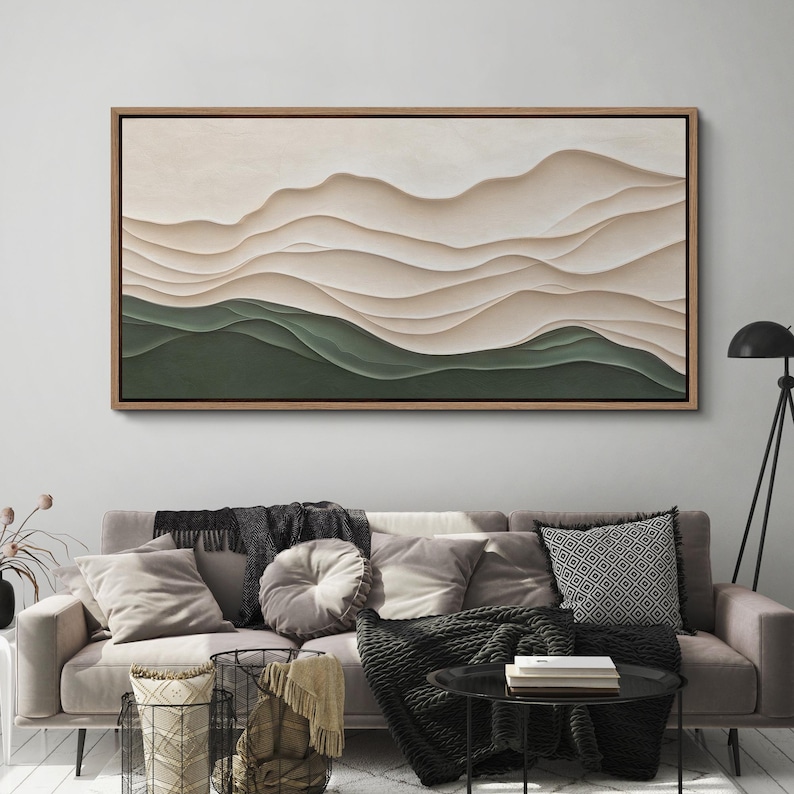May include: A framed abstract landscape painting with a layered, textured design. The painting features a series of soft, flowing lines in shades of beige and white, creating a sense of depth and movement. The bottom of the painting is a solid green color.