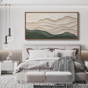 May include: A modern bedroom interior with a large abstract painting of layered beige and green waves hanging above a bed with a white duvet and a black and white throw blanket.