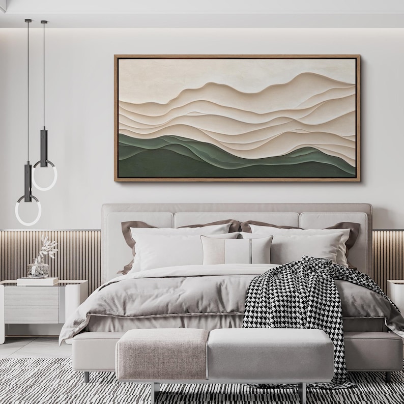 May include: A modern bedroom interior with a large abstract painting of layered beige and green waves hanging above a bed with a white duvet and a black and white throw blanket.