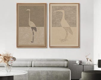 May include: Two framed artworks with crane designs. Each piece has a two-tone background with a dotted pattern. The cranes are minimalist. The frames are natural wood. Ideal for a living room or bedroom.