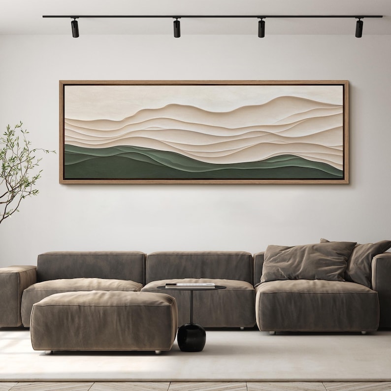 May include: A long, horizontal abstract painting with a layered, textured design. The painting features a series of soft, flowing lines in shades of beige and brown, creating a sense of depth and movement. The bottom portion of the painting is a solid green color.