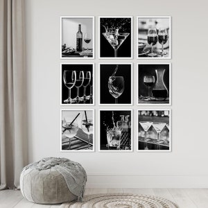 May include: A set of eight black and white framed prints featuring various images of wine glasses and cocktails. The prints are arranged in a grid pattern on a white wall.