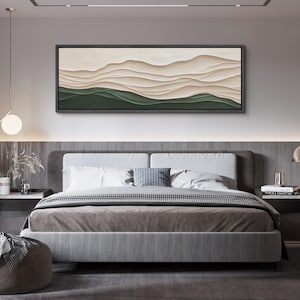 May include: A modern bedroom with a gray headboard and a bed with a brown and white patterned blanket. A large abstract painting with beige and green colors hangs above the bed.