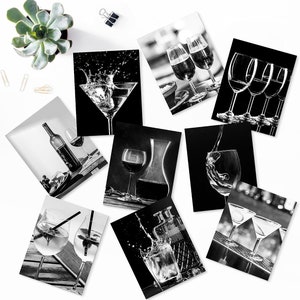 May include: A set of nine black and white photographs featuring various wine glasses and cocktails. The images are printed on white cardstock and are perfect for framing.