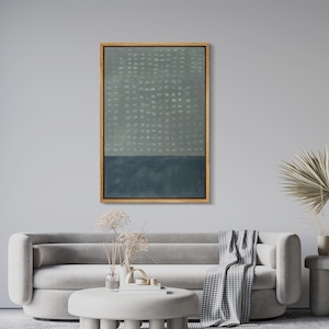 May include: Abstract art print in a rectangular wooden frame. The artwork features a two-tone design with a light green dotted upper section and a dark blue lower section. The frame is a warm gold color, adding a touch of elegance to the piece.