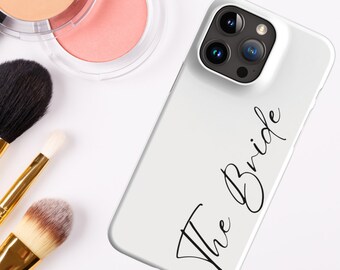 May include: White iPhone case with a black inscription that reads "The Bride".