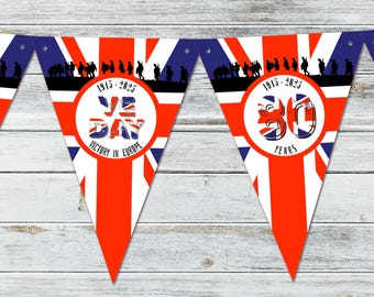 May include: A red, white, and blue bunting with a Union Jack design. The bunting has a circle with the text "VE DAY" and "VICTORY IN EUROPE" in the center. The bunting also has a circle with the text "1945-2025 80 YEARS" in the center.