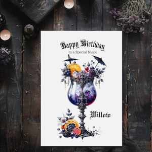 May include: A birthday card with a gothic theme. The card features a detailed illustration of a cocktail glass filled with fruit and berries. The text reads "Happy Birthday to a Special Niece" and the name "Willow".