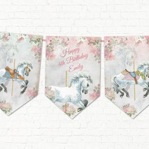 May include: A banner with three pennants featuring carousel horses and floral designs. The center pennant reads "Happy 4th Birthday Emily" in pink script. The horses are white with blue and gold accents, set against a backdrop of pink roses.