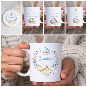 Könnte beinhalten: Eine Sammlung weißer Keramikbecher und ein Untersetzer mit Strickmotiven. Die Becher zeigen Sätze wie „Mögen deine Maschen nie fallen“ und „So viele Muster“. Die Designs umfassen Garn, Stricknadeln und eine Teekanne. Der Untersetzer und ein Becher sind mit dem Namen „Caroline“ personalisiert.