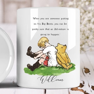May include: White ceramic mug featuring a watercolor illustration of a child putting on boots, with a yellow teddy bear. The mug has a quote: "When you see someone putting on his Big Boots..." and the name "William".