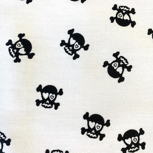 Könnte beinhalten: Weißer Stoff mit einem sich wiederholenden Muster aus schwarzen Totenköpfen und Knochen mit Herzen als Augen.