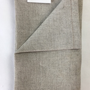 May include: A folded gray linen kitchen towel with a white label that reads "Rip Snorters Handmade".