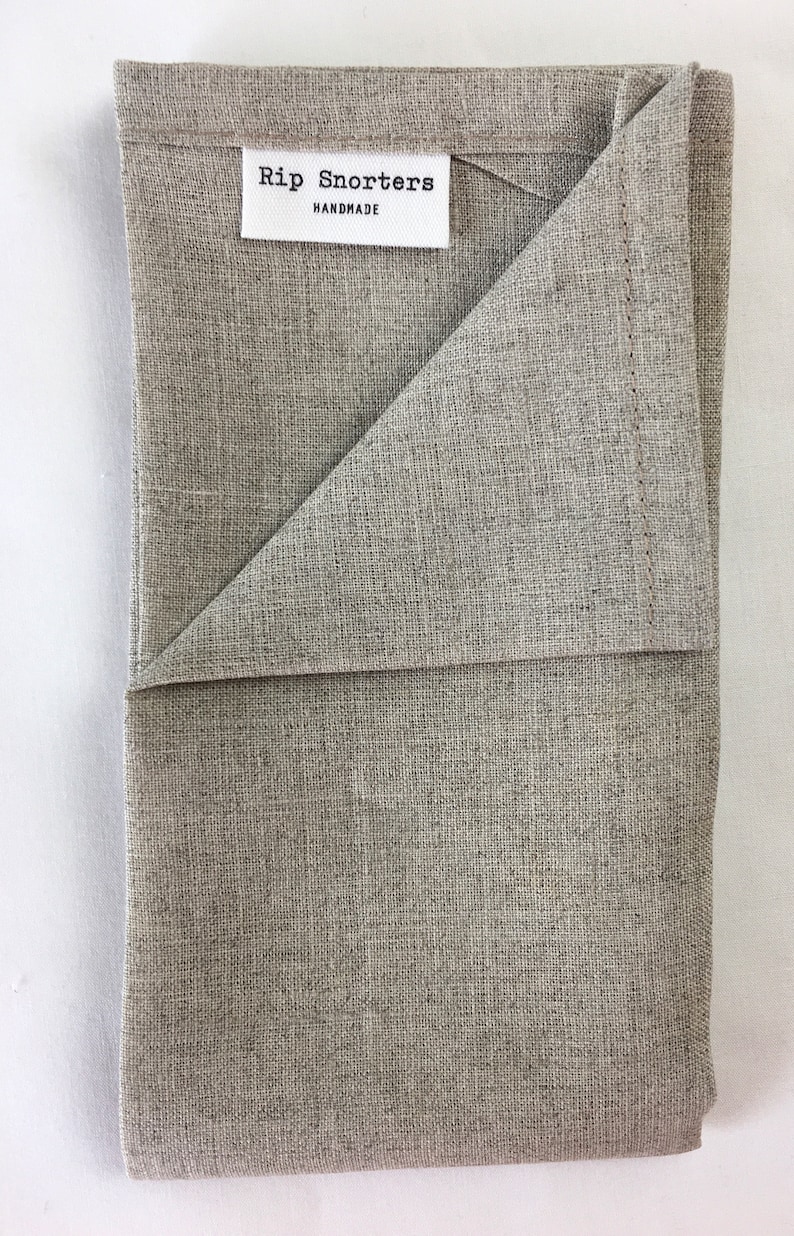 May include: A folded gray linen kitchen towel with a white label that reads "Rip Snorters Handmade".