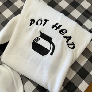 Puede incluir: Sudadera blanca con texto bordado en negro que dice "POT HEAD" y una imagen bordada en negro de una cafetera.