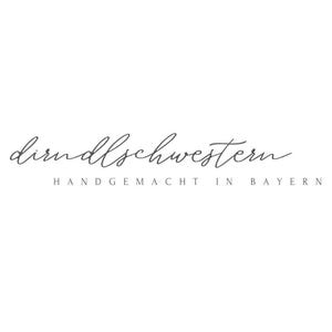May include: A logo with the cursive text "dirndlschwestern" in a dark gray color. Below the cursive text is the text "HANDGEMACHT IN BAYERN" in a sans-serif font, also in dark gray. The background is white.
