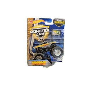 May include: A Hot Wheels Monster Jam Avenger monster truck toy in its original packaging. The silver and yellow truck features large black tires and is displayed on a blue card with the text Monster Jam, 25, and includes team flag.