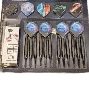 May include: A Win.Max dart set combo for four players in black packaging. The set includes twelve black darts with blue-patterned flights, four spare flight designs, and a small plastic accessory case with an instruction card included.