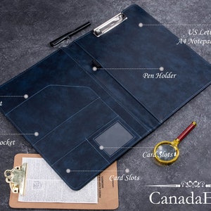 May include: A dark blue leather-like portfolio folder featuring a metal clipboard clip, a pen holder, two open pockets, and card slots. The interior is labeled with text indicating it is a US Letter size and A4 notepad holder.