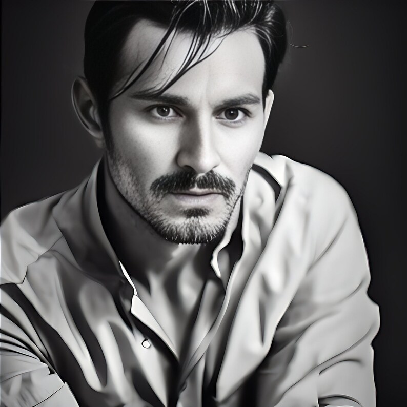 May include: Black and white portrait of a person with dark hair and a neatly trimmed beard and mustache. The person is wearing a light-colored button-down shirt, with the top button undone. The background is a dark gray.