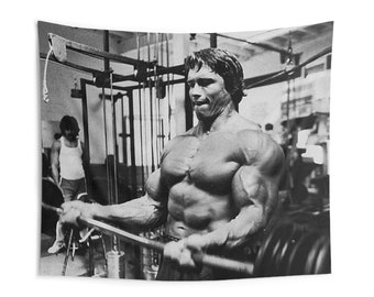 May include: Monochrome wall hanging depicting a bodybuilder exercising with weights in a gym setting. The image highlights the bodybuilder's muscular form and gym apparatus. The tapestry is rectangular in shape.