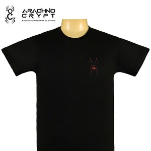 May include: Black t-shirt with a red and black spider embroidered on the front. The shirt has a crew neck and short sleeves. The text "Arachno Crypt" is printed on the top of the shirt.
