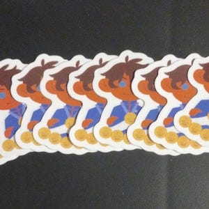 May include: A set of ten stickers featuring a cartoon character wearing a blue shirt and holding a gold medal. The character has brown hair and skin, and is smiling.