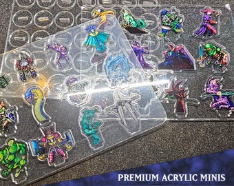 Puede incluir: Un conjunto de 16 figuras en miniatura de acrílico, que representan criaturas y personajes de fantasía. Las miniaturas se muestran en una lámina de acrílico transparente con un patrón de cuadrícula. El conjunto está etiquetado como "Premium Acrylic Minis Monster Pack 6".