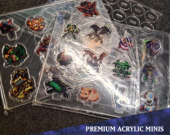 Pode incluir: Um conjunto de 16 miniaturas acrílicas que representam várias criaturas fantásticas, incluindo um dragão, um goblin, uma tartaruga e um hamster. As miniaturas estão dispostas em uma folha de plástico transparente com o texto "PREMIUM ACRYLIC MINIS MONSTER PACK 1".