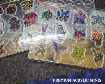 Può includere: Un set di 20 miniature in acrilico trasparente, che rappresentano varie creature e personaggi fantastici. Le miniature sono disposte su due fogli di acrilico trasparente, con il testo "PREMIUM ACRYLIC MINIS" e "MONSTER PACK 3" stampato in basso.