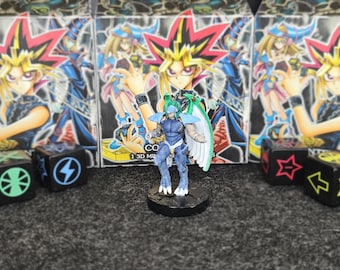 Puede incluir: Una figura azul y blanca de un personaje con alas, sobre una base negra. La figura está frente a tres cajas con ilustraciones de estilo anime. Dados con símbolos en primer plano.