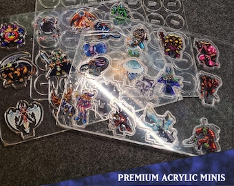 May include: A set of 16 acrylic miniatures featuring various fantasy creatures, including a dragon, a knight, a goblin, and a wizard. The miniatures are arranged on a clear acrylic sheet with a grid pattern. The set is labeled "PREMIUM ACRYLIC MINIS MONSTER PACK 2".