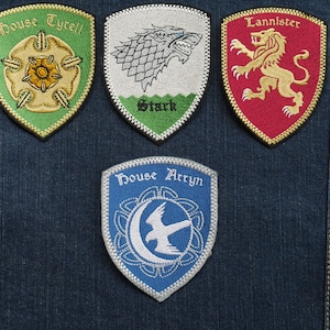 Può includere: Quattro toppe ricamate con gli stemmi delle case Lannister, Stark, Tyrell e Arryn della popolare serie televisiva Il Trono di Spade. Le toppe sono rosse, bianche, verdi e blu.