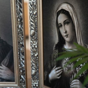 May include: Two framed religious images, one depicting Jesus Christ and the other depicting the Virgin Mary. Both images are in black and white and feature ornate silver frames.