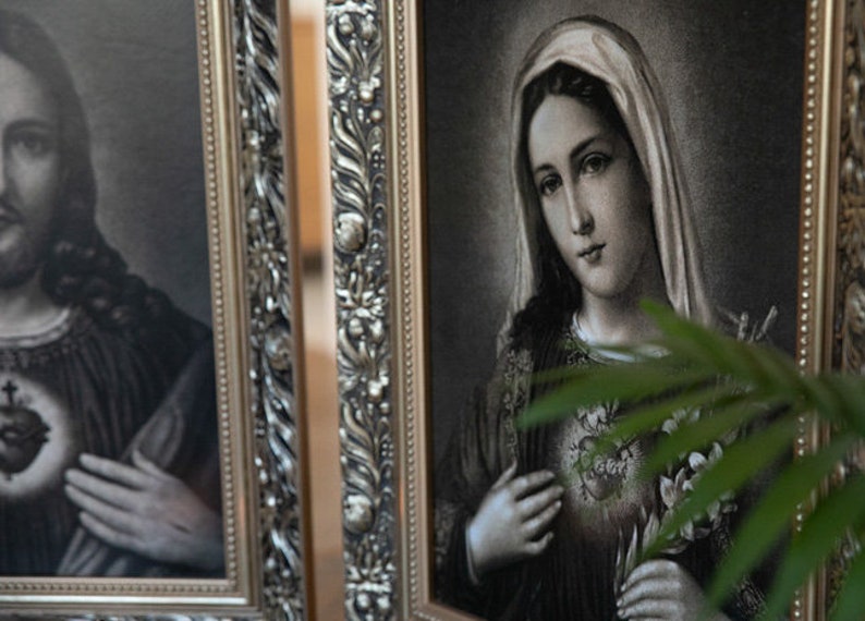May include: Two framed religious images, one depicting Jesus Christ and the other depicting the Virgin Mary. Both images are in black and white and feature ornate silver frames.