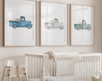 May include: A white crib with a white mattress and a white wooden high chair. There are three framed prints of vintage blue and green pickup trucks on the wall. There are also stuffed animals and a woven basket with a stuffed animal inside.