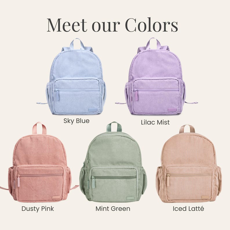 K&ouml;nnte beinhalten: F&uuml;nf Rucks&auml;cke aus Cord in verschiedenen Farben: Himmelblau, Flieder, Staubrosa, Mintgr&uuml;n und Iced Latte. Jeder Rucksack hat eine Vordertasche, Seitentaschen und einen oberen Griff. Der Text "Meet our Colors" ist oben zu sehen.